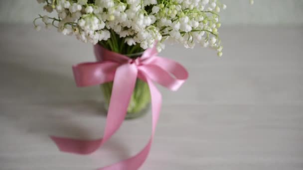 Chaussures pour enfants sont sur la table près d'un bouquet de fleurs. Pour une fête de bébé. pour décor d'anniversaire thématique — Video