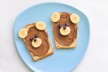 Çocuk sandviç çikolata fıstıklı yapıştırın ve muz bear, şeklinde yalan bir tabloda bir plaka üzerinde
