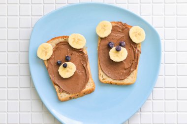 Çocuk sandviç çikolata fıstıklı yapıştırın ve muz bear, şeklinde yalan bir tabloda bir plaka üzerinde