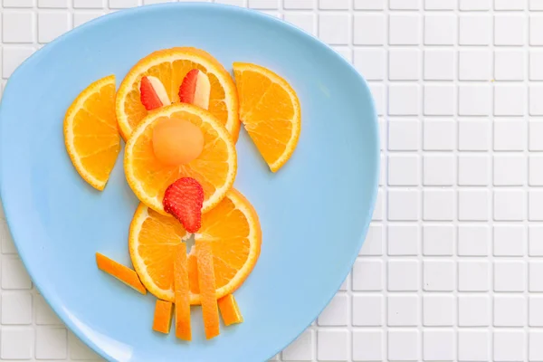 Um café da manhã de crianças de uma laranja na forma de um cão. sobremesa para bebê, animal em prato — Fotografia de Stock