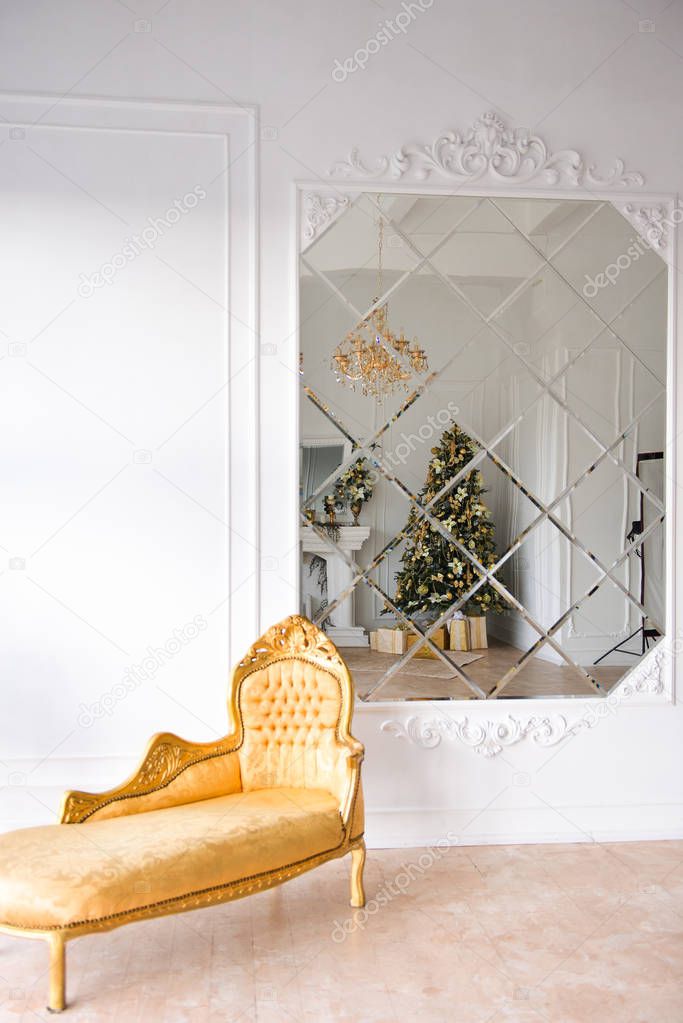 Christmas decor in studio of a classic style living room with a vintage armchair, fireplace, Christmas tree. New Years interior