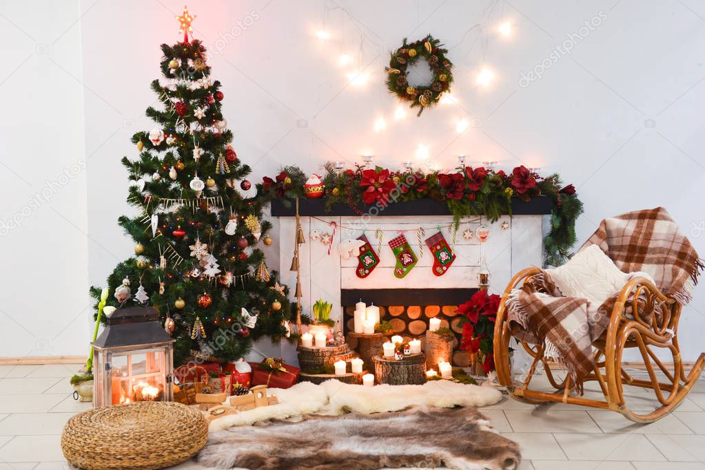 interior photo studio with Christmas decor. Fireplace, Christmas tree, gifts of the New Years scenery