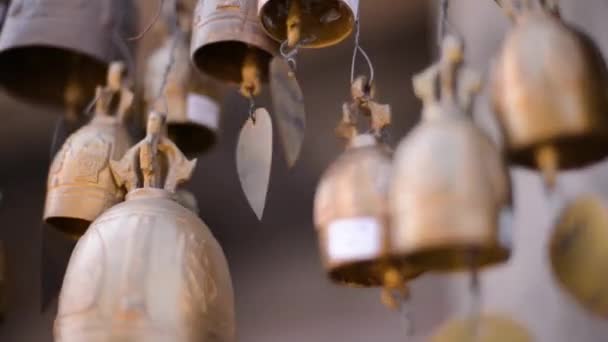 Boeddhistische klokken met wensen swingen in de wind in de buurt van de tempel — Stockvideo