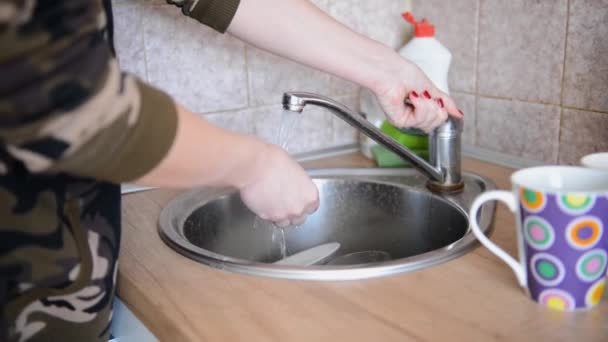 Las manos de las mujeres lavando platos en la cocina en un fregadero de cromo — Vídeos de Stock