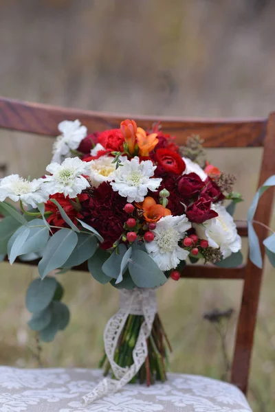 Heldere herfst bruiloft bruids boeket, staande op een stoel in het bos. Floral regeling van bloemen vieren vakantie decor — Stockfoto