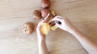 elinde bir bıçakla patates soyarken oldu. Üstten görünüm. tarifi yemekler, evde çekilmiş video