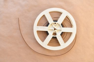 Eski vintage sinematik makaraları bir video film ile Kraft yüzey arka plan üzerinde yalan. Üstten görünüm.