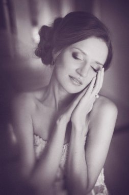 Hassasiyet moda gelin. Genç güzel kız mükemmel cilt ve makyaj, rhinestones ve dantel, saçında çiçekler ile bir gelinlik modeli. Yumuşak odak, tonlama