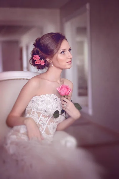 Zärtlichkeit Mode Braut. junge schöne Model-Mädchen mit perfekter Haut und Make-up, in einem Hochzeitskleid mit Strass und Spitze, Blumen im Haar. weicher Fokus, straffende Wirkung — Stockfoto