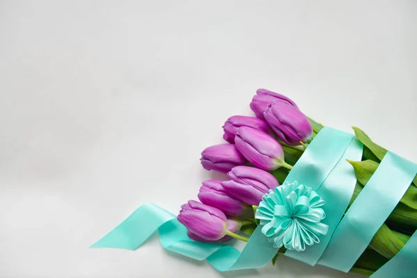 Тюльпани з синьою стрічкою на ізольованому білому фоні святковий букет на день народження, 8 березня, дитячий душ, день матері, жіночий день. флористичний — стокове фото