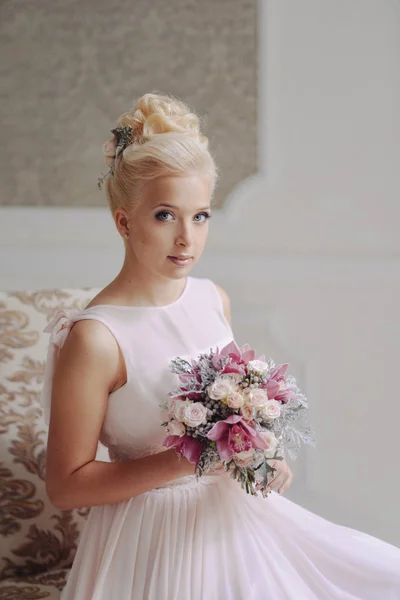 Портрет элегантной модели невесты-блондинки в нежном платье со свадебным букетом из роз и орхидей в помещении — стоковое фото