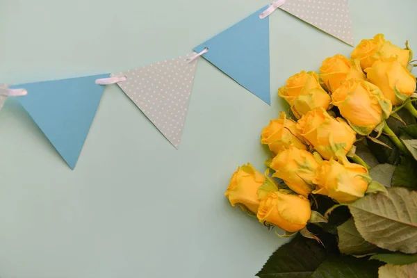 Um buquê de rosas amarelas flores com folhas em um fundo azul isolado. Deitado plano, vista superior. cartão postal aniversário arranjo floral — Fotografia de Stock