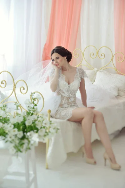 Młody atrakcyjny model kobieta dziewczyna przed ślubem, siedząc na łóżku. Rano buduar panny młodej. Piękna bielizna i sukienka, delikatne obrazu — Zdjęcie stockowe