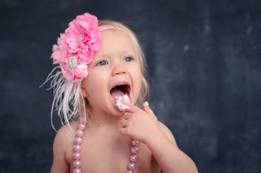 temalı doğum günü için eğlenceli bir duygusal kız sarışın siyah bir zemin üzerine pembe renkli pasta şut. stilize Fotoğraf oturumu geleneği ile tatlı dekor ve balon