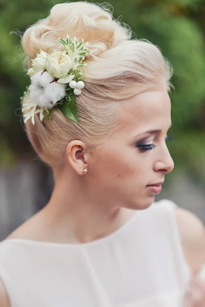 Свадебная прическа для блондинки невесты с аксессуарами шпильки из свежих цветов — стоковое фото