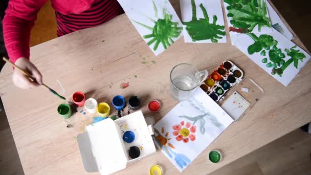 Childrens handen trekken aquarellen op oppervlak van houten tafel op papier. Kid creativiteit, familie hobby aquarel schilderij schilderijen. bovenaanzicht — Stockvideo