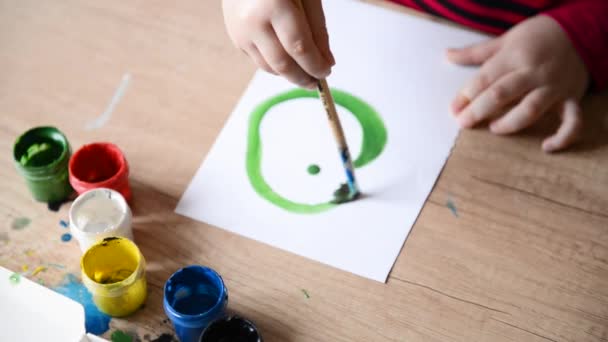 Kinderhände malen grüne Kreis-Aquarelle auf die Oberfläche eines Holztisches auf Papier. Kinder Kreativität, Familie Hobby Aquarellmalerei Gemälde — Stockvideo