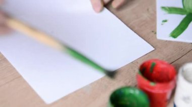beyaz kağıt çocuk suluboya boya ile masaya koyar ve yeşil olan siyah bir daire çizer. Bebek sanat sanatçı