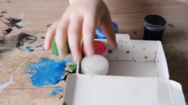 Çocuk el boya... kutularını kutusuna lekeli masanın üzerine koyar. yaratıcı süreç, yaratıcı pisliği temizleme tamamlandı