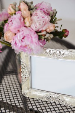 pembe çiçek, yumuşak odak bir buket yanında masada bir fotoğraf için gümüş çerçeve