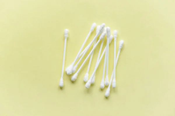 पिवळा पार्श्वभूमीवर प्लास्टिकच्या तळाशी पांढरा कापूस कान स्टिक — स्टॉक फोटो, इमेज