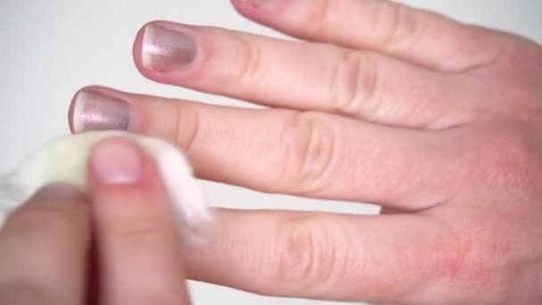 Donna che fa manicure mani cura lava smalto con un batuffolo di cotone su uno sfondo bianco — Video Stock