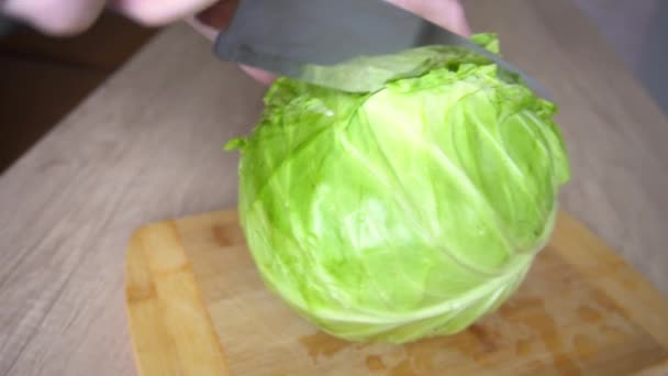 Frauenhände schneiden Grünkohl auf einer hölzernen Oberfläche des Küchentisches — Stockvideo