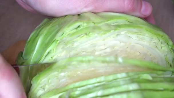 Frauenhände schneiden Grünkohl auf einer hölzernen Oberfläche des Küchentisches, Nahaufnahme — Stockvideo