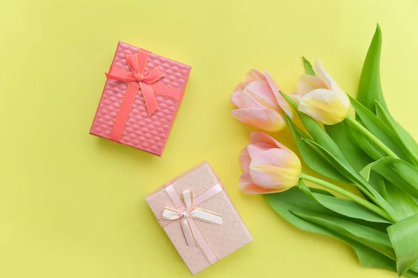 Букет з тюльпанів і подарункових коробок на ізольованому жовтому фоні, флористичні Квіткові композиції квітів на 8 березня Міжнародний день матері листівка листівка — стокове фото