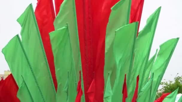 Grupo de bandeiras vermelho-verdes em um fundo branco está sendo desenvolvido em uma verta para decorar a cidade. Decoração durante as férias — Vídeo de Stock