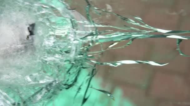 Skottsäkert glas efter testet, sprickor och bucklor på fönstret från kulan på utställningen av vapen — Stockvideo