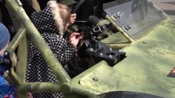 BELARUS, MINSK, 17 de maio de 2019: 9th International Exhibition of Armament and Military Equipment Milex - 2019. rowd of children climbed into a machine of military origin, they are learning and playing — Vídeo de Stock