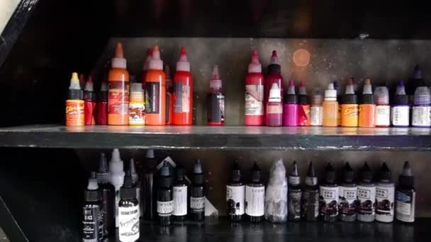 Belorusszia, Soligorsk, 22 május 2019: különböző többszínű tinták pigmentek a jar a festék a polc tetoválás — Stock videók