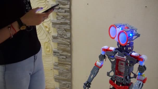 Belarus, Minsk, Robot Sergisi, 3 Haziran 2019: kız kapalı telefon kullanarak robot kontrol eder ve robot nasıl çalıştığını çocuk ve babası gösterir — Stok video