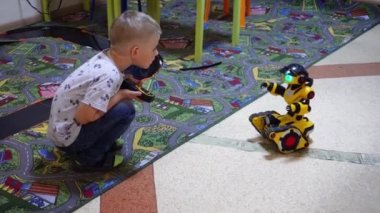 Beyaz Rusya, Minsk, Robot Sergisi, Haziran 3, 2019: çocuk oyuncak robot traktör adam çocuk odasında sürmek çocuk oynuyor