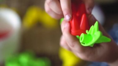 Çocuk bir dinozor şeklinde tasarımcı bina kiti ile bir kanepeüzerinde kapalı oynar. Çocuk parmakları bir tornavida ile parlak renkli bir bulmaca oyuncak toplamak. Close