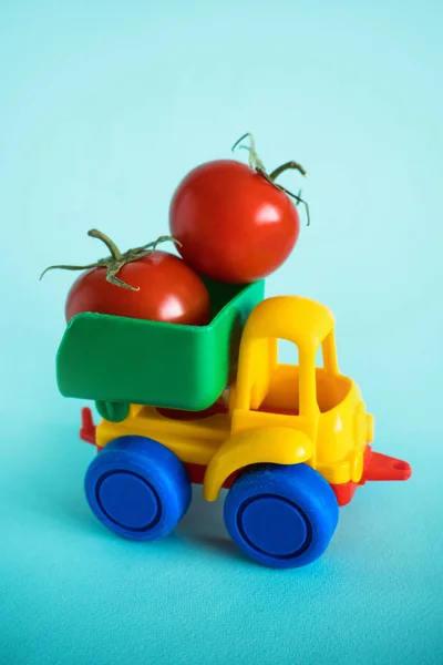 tomatoes natural vitamins are in the back of truck in a childrens toy car food delivery truck logistics