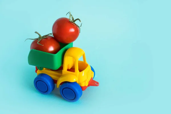 Vitaminas naturais tomates estão na parte de trás do caminhão em um carro de brinquedo infantil entrega de alimentos logística caminhão Fotos De Bancos De Imagens