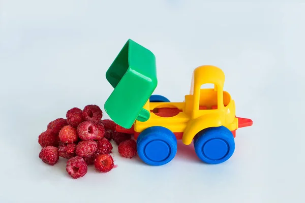 raspberries natural vitamins are in the back of truck in a childrens toy car food delivery truck logistics
