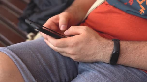 Mužská ruka držící moderní mobilní telefon, člověk si začíná psát SMS, kecat s přáteli, zblízka