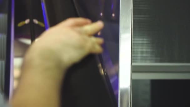 Rozmazaný obraz lidí přidržených zábradlí při vzestupném eskalátoru v nákupním středisku mužská ruka — Stock video
