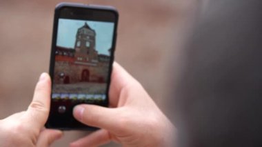mans eller turist Mir Kalesi'nde Belarus turunda telefonunda fotoğraf ve video çeker. Close