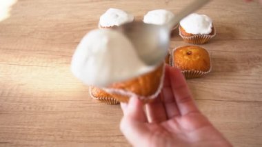 Tatlı şeker sır krem ile Paskalya kekler süsleyin. Kaşık kullanarak. closeup ev pişirme konsepti