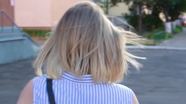 Pensive fiatal nő séta a városban naplementekor háttérvilágítással — Stock videók