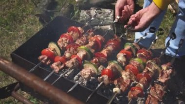 mens eller kömürler üzerinde sigara bir parkta brazier üzerinde pişirilen şişler üzerinde parlak sebze et şişler üzerinde açmak