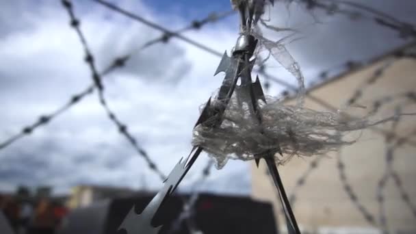 Ribbon wavers on fence with barbed wire outdoor sky background close-up — Stock Video