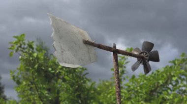 bulutlu gökyüzüne karşı eski ev hava Vane hızlı bir yaz bulutlu gün rüzgar güçlü rüzgarlar altında rüzgar döner