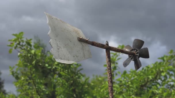 Stará domácí meteorologická větrná lopatka proti zatažené obloze se rychle otáčí ve větru pod silnými nárazy větru v letní oblačné den — Stock video