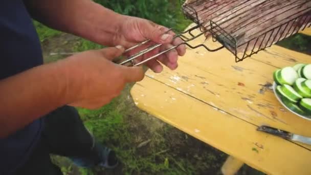 Eller erkek yakın ızgara için balık et koyarak - Barbekü pişirme ve temiz havada bir yemek paylaşımı Kavramı. Köy yaşam tarzı — Stok video