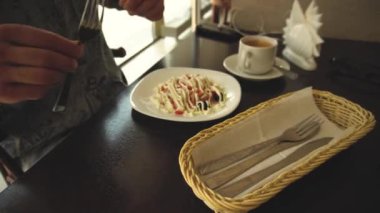 Taze ve mayonez ile bir salata ahşap bir masada oturan yemek için hazır bir öğle molası sırasında adam kırpılmış görüntü bir çatal ve elinde bir bıçak alır